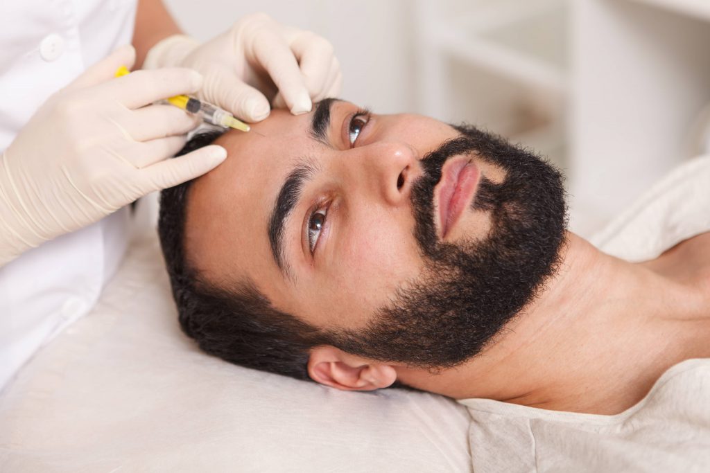 bearded-man-getting-face-filler-injections-by-cosmetologist